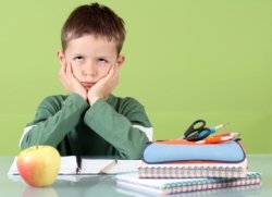 Bored Elementary School Boy Writing Assignment